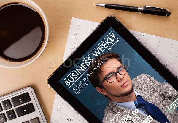 Workplace with tablet pc showing magazine cover and a cup of coffee on a wooden work table closeup Stock photo © ra2studio