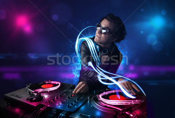 Disc jockey playing music with electro light effects and lights Stock photo © ra2studio