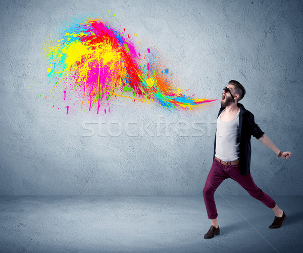 Hipster guy shouting colorful paint on wall Stock photo © ra2studio