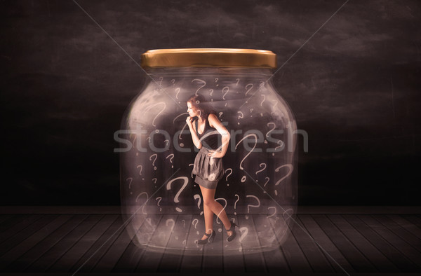 Businesswoman locked into a jar with question marks concept Stock photo © ra2studio