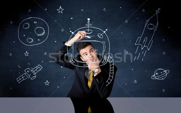 Sales person drawing helmet and space rocket Stock photo © ra2studio