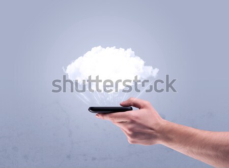 Hand holding phone with empty cloud Stock photo © ra2studio