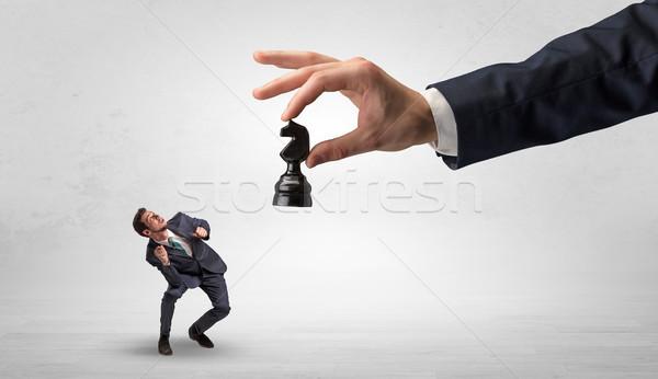 Stock photo: Big hand with chessman down small weak businessman concept