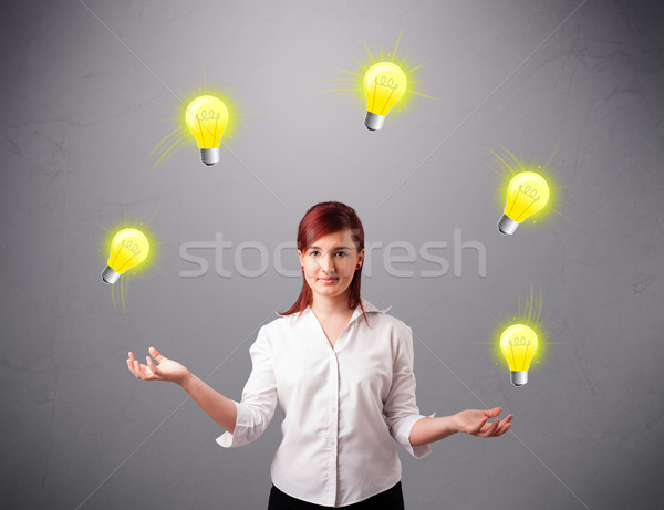 young lady standing and juggling with light bulbs Stock photo © ra2studio