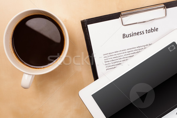 Workplace with tablet pc showing media player and a cup of coffee on a wooden work table closeup Stock photo © ra2studio