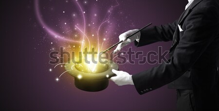 Stock photo: Worker with airbrush painting with glowing golden paint 