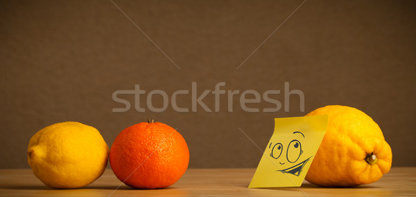 Lemon with post-it note looking curiously at citrus fruits Stock photo © ra2studio