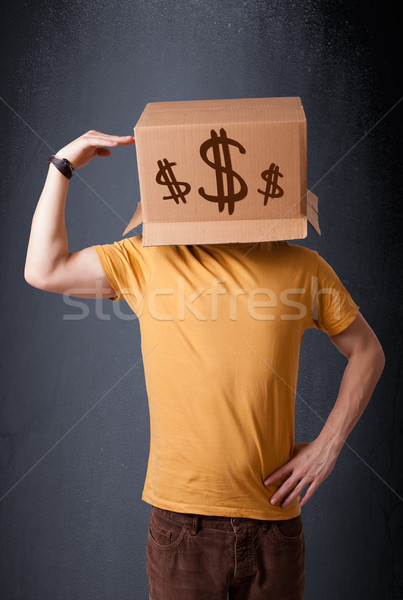 Young man gesturing with a cardboard box on his head with dollar Stock photo © ra2studio