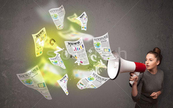 Girl yelling into loudspeaker and newspapers fly out Stock photo © ra2studio