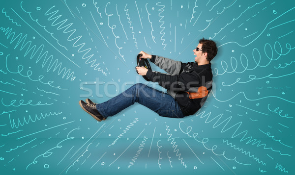 Stock photo: Funny guy drives an imaginary vehicle with drawn lines around hi