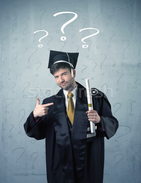 Stock photo: Young graduate teenager with question marks drawn