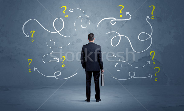 Unsure businessman with question marks Stock photo © ra2studio