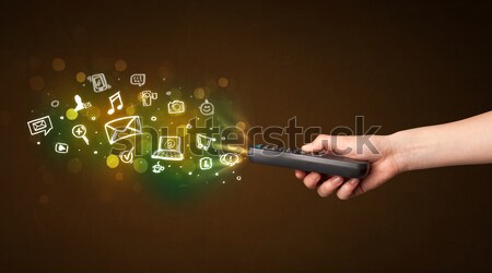 Hand with remote control and social media icons Stock photo © ra2studio