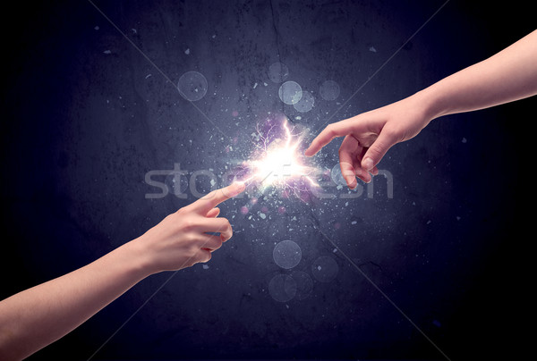 Hands reaching to light a spark Stock photo © ra2studio
