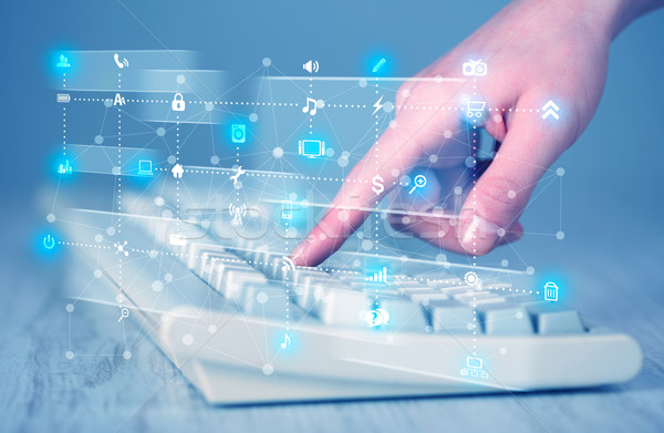 Hand pressing keyboard with high tech media icons Stock photo © ra2studio