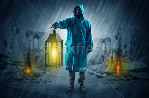 Man with a glowing lantern at a catastrophe scene Stock photo © ra2studio
