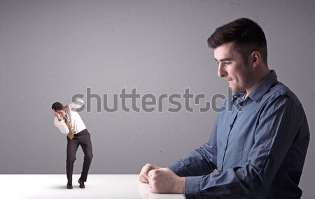 Young businessman fighting with miniature businessman Stock photo © ra2studio