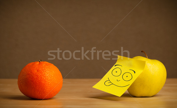 Apple with post-it note sticking out tongue to orange Stock photo © ra2studio