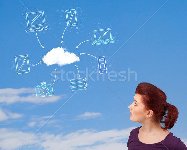 Stock photo: Casual girl looking at cloud computing concept on blue sky