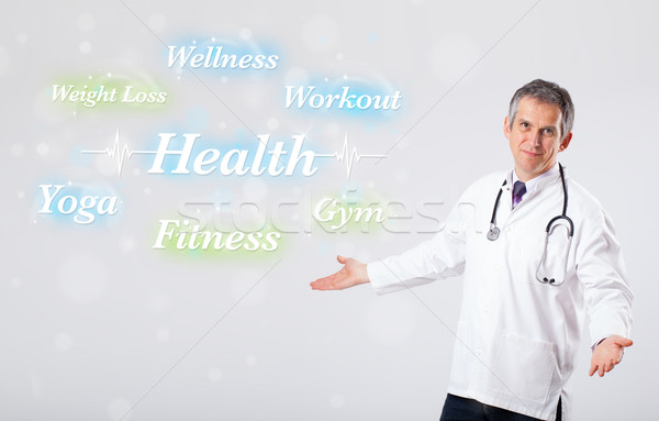 Clinical doctor pointing to health and fitness collection of wor Stock photo © ra2studio