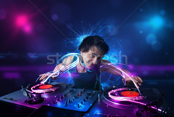 Stock photo: Disc jockey playing music with electro light effects and lights