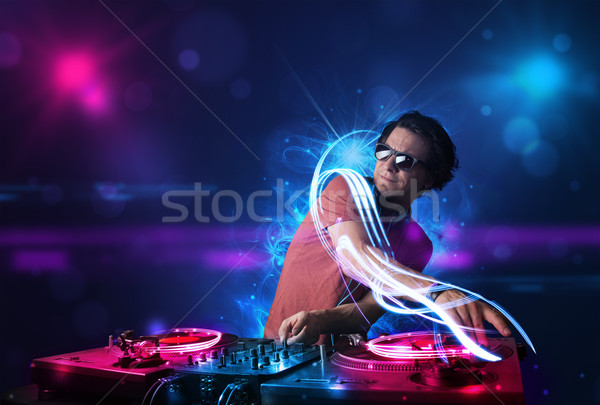 Disc jockey playing music with electro light effects and lights Stock photo © ra2studio