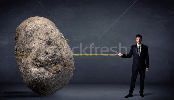 Businessman pulling huge rock with a rope  Stock photo © ra2studio