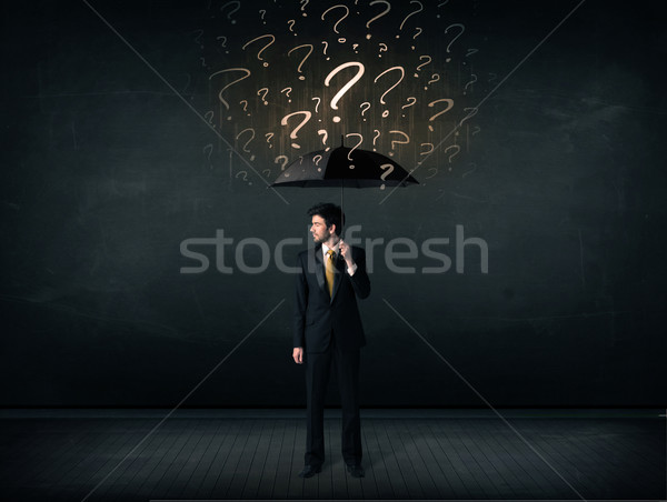 Businessman with umbrella and a lot of drawn question marks Stock photo © ra2studio