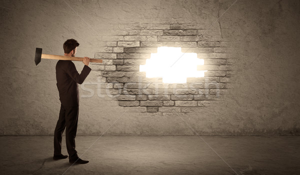 Business man hitting brick wall with hammer and opening a hole Stock photo © ra2studio