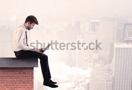 Office worker sitting on rooftop in city Stock photo © ra2studio