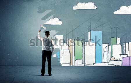 Salesman painting tall buildings on urban wall Stock photo © ra2studio