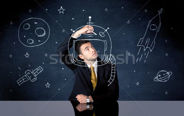 Sales person drawing helmet and space rocket Stock photo © ra2studio