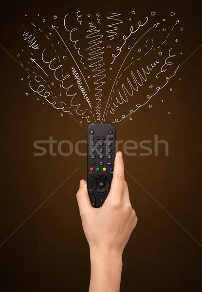 Hand with remote control and curly lines Stock photo © ra2studio