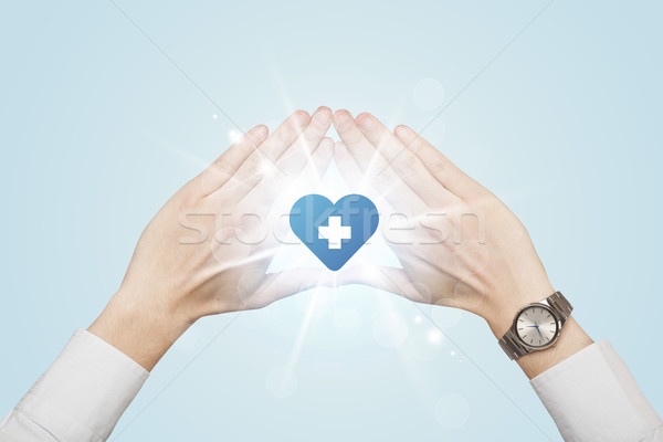 Stock photo: Hands creating a form with heart blue cross