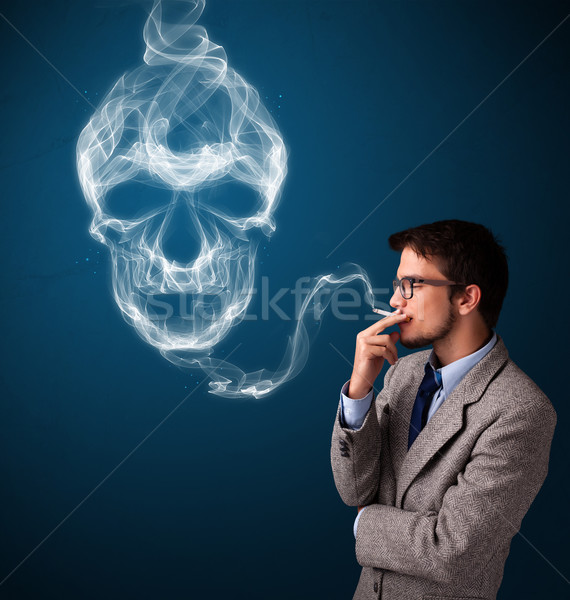 Young man smoking dangerous cigarette with toxic skull smoke Stock photo © ra2studio