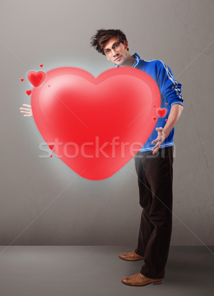 Young man holding lovely 3d red heart Stock photo © ra2studio