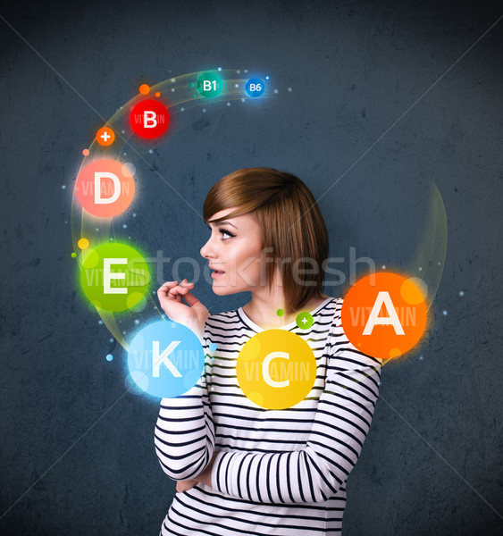 Young woman thinking with vitamins circulation around her head Stock photo © ra2studio