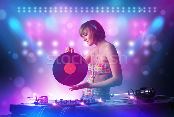 Disc jockey mixing music on turntables on stage with lights and  Stock photo © ra2studio
