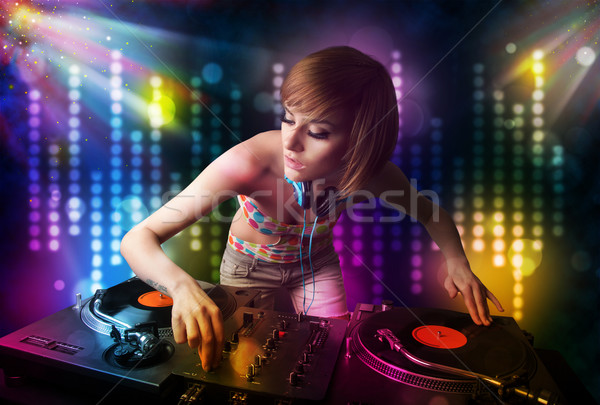 Dj girl playing songs in a disco with light show Stock photo © ra2studio