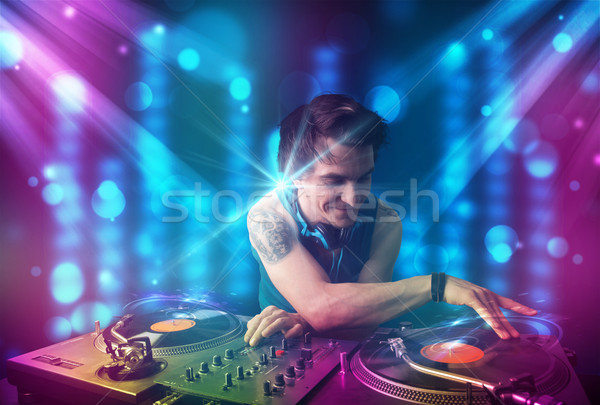 Dj mixing music in a club with blue and purple lights Stock photo © ra2studio