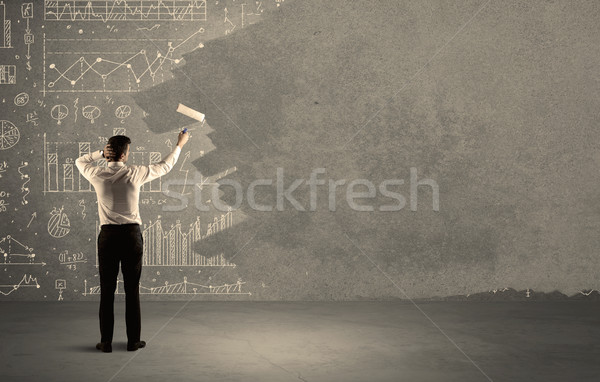 Salesman painting over charts on wall Stock photo © ra2studio