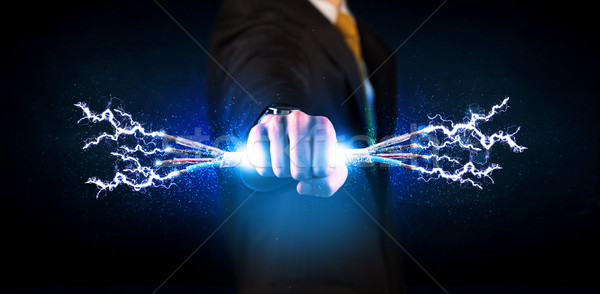 Business person holding electrical powered wires Stock photo © ra2studio
