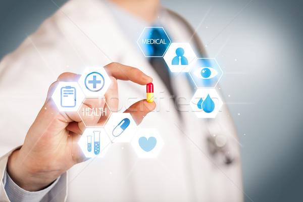 A doctor in white holding a pill Stock photo © ra2studio