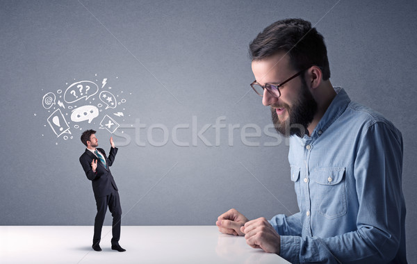 Young businessman fighting with miniature businessman Stock photo © ra2studio
