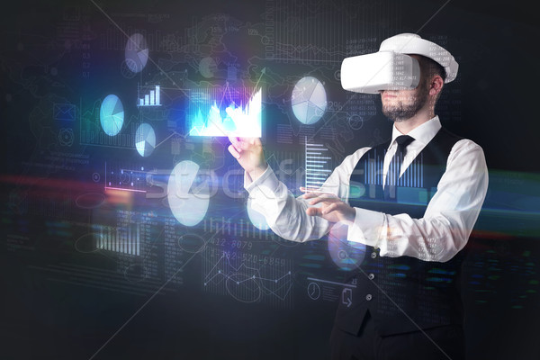 Man wearing VR goggles with charts and reports Stock photo © ra2studio