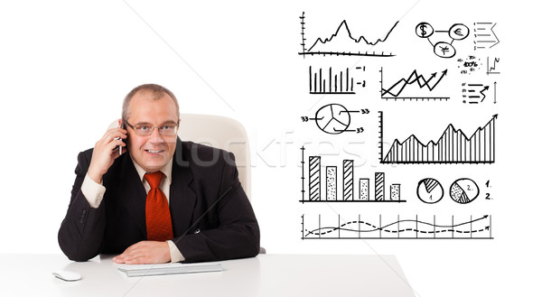 Businessman sitting at desk with diagrams and making a phone call, isolated on white Stock photo © ra2studio