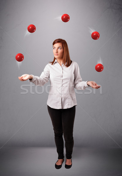 Stock photo: young girl standing and juggling with red balls