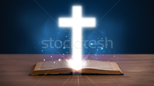 Open holy bible with glowing cross in the middle Stock photo © ra2studio