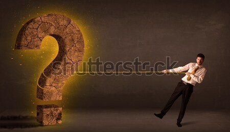 Business man pulling a big solid question mark stone Stock photo © ra2studio