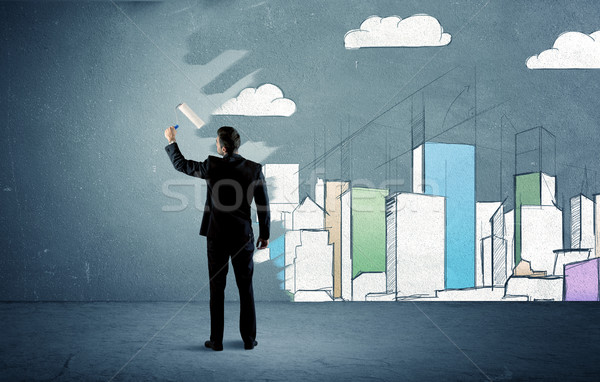 Salesman painting tall buildings on urban wall Stock photo © ra2studio